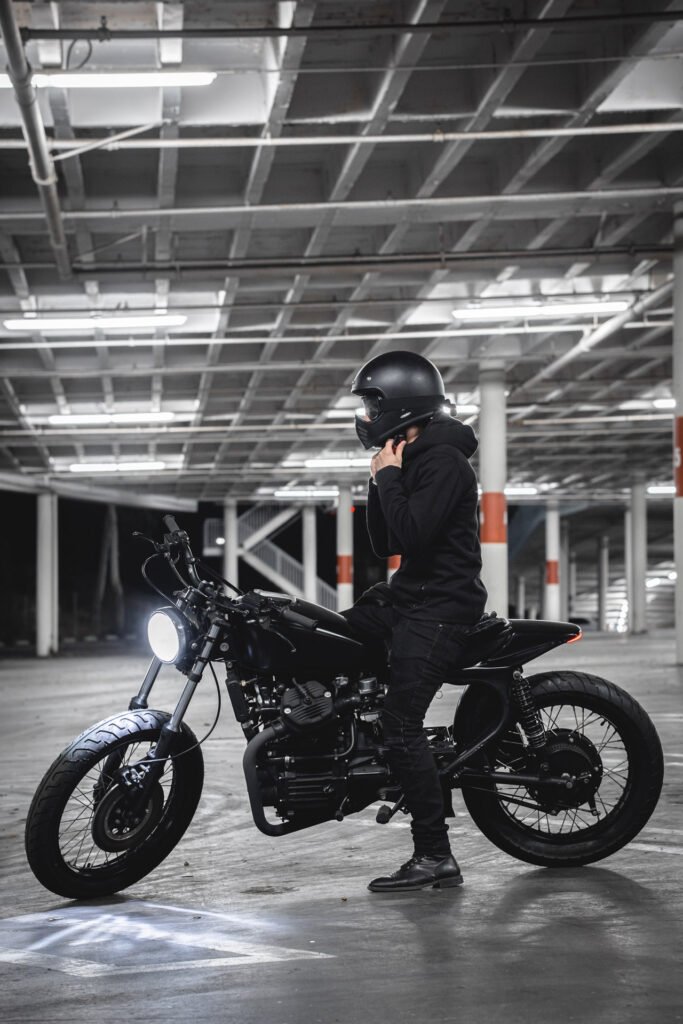 Profile shot of CX500 with Motorcycle rider sitting atop strapping his helmet on. 